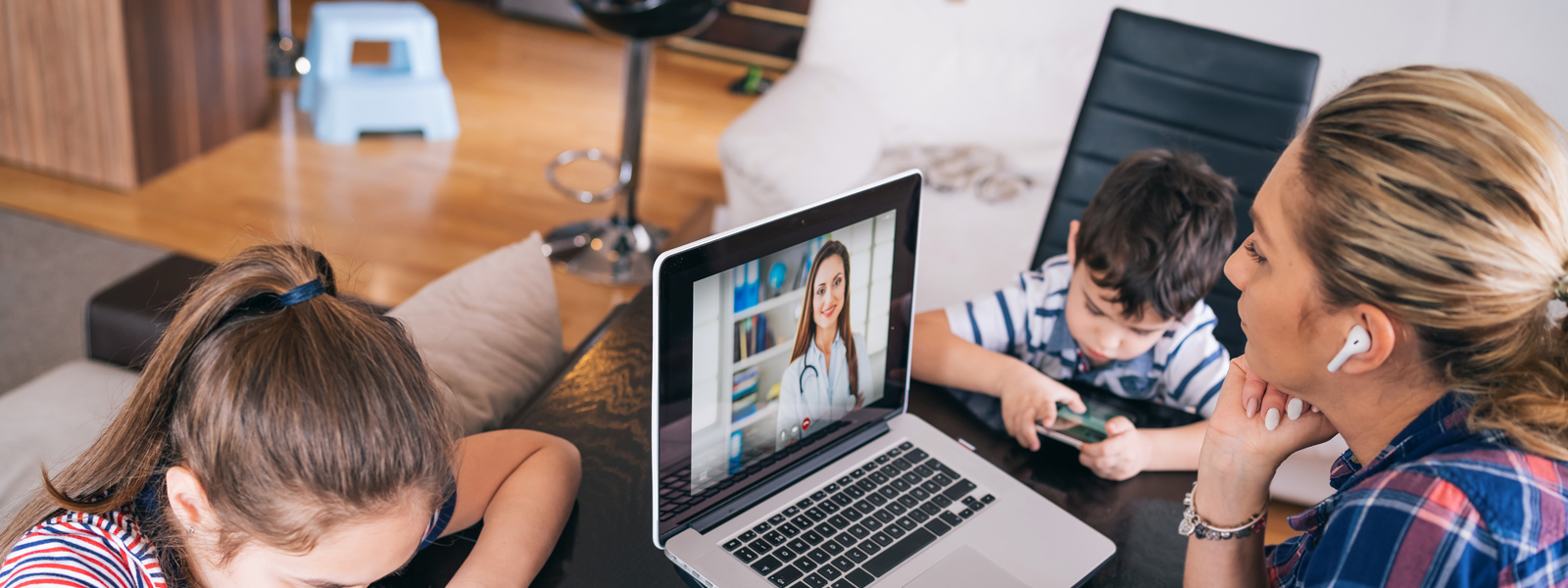 woman watching professional screencast with earbuds and child nearby