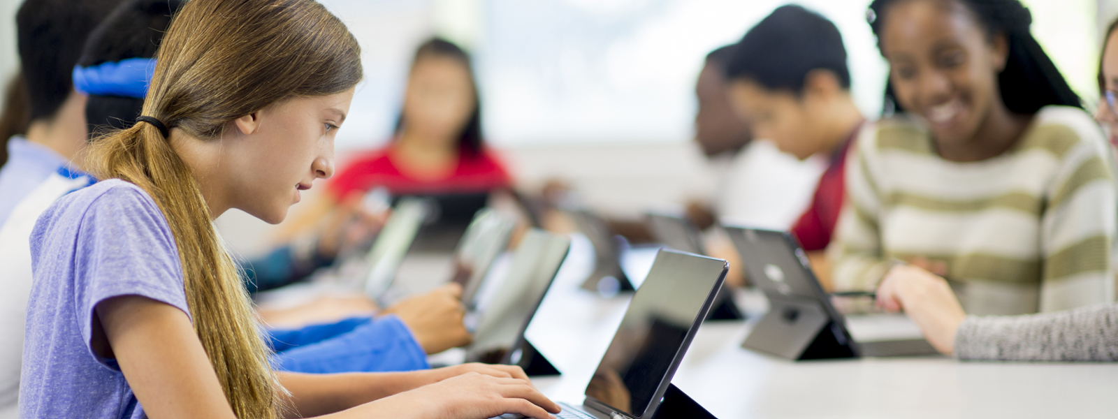 students working individually at a row of workstations
