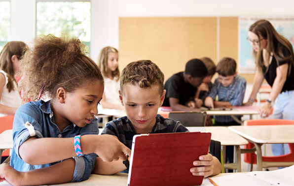 students working in pairs using a tablet