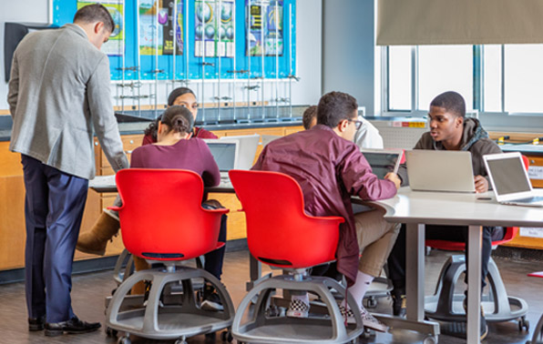 students working in teams, teacher supervising